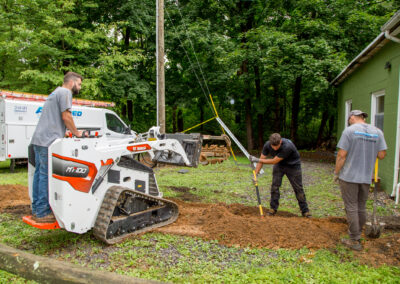 Digging alongside a trencher during underground electrical service installation