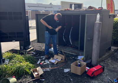 Electrician servicing electrical connections inside an outdoor equipment cabinet