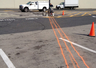 Saw cutting asphalt to refeed parking lot lighting